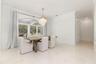 Bright interior space featuring large arched windows, crown molding, a decorative chandelier.