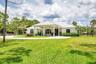 White stucco exterior with a metal roof and an arched portico entry