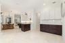 Spacious kitchen and dining area, extended area for a coffee bar or serving area with an abundance of cabinets, recessed lighting, and a kitchen islan