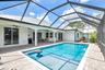 Screened swimming pool enclosure with paver patio