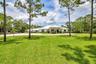 Spacious front lawn with mature trees and a circular driveway