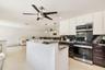 Kitchen featuring white upper cabinetry, dark lower cabinetry, stainless steel appliances, and contrasting countertops with backsplash