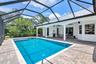 Expansive screened lanai featuring a swimming pool, paver deck, and covered patio