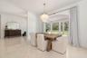 Dining area featuring a large arched window, a decorative chandelier.