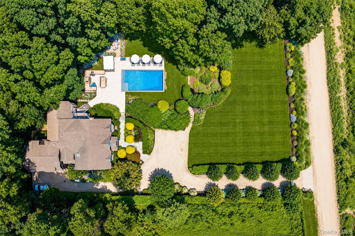Expansive property featuring a large residence, a rectangular swimming pool, and extensive manicured lawns