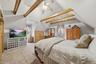 The primary bedroom is such an intimate space with vaulted ceilings, exposed beams and a knee wall closet with barn doors.