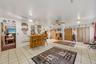 The finished basement features 2 rooms, one a gathering room and the other a bar/play area with tiled floor and an entrance to the driveway.
