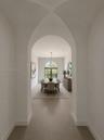 Art passage way from great room to dining room. AI Staged.