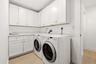 Thoughtfully designed for everyday convenience, the spacious laundry room features abundant custom cabinetry, extensive countertop workspace for foldi