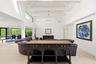 The heart of the home is an impressive open-concept living space defined by soaring vaulted ceilings, exposed beams, skylights, and an abundance of na