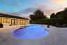 As the sun sets, this remarkable backyard transforms into a private evening retreat where luxury and nature exist in perfect harmony. Backing to a pro