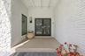 A welcoming covered entry beautifully blends timeless Old Florida charm with sophisticated modern design. Painted white brick and natural stone create