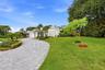 A striking first impression begins with a sweeping paver driveway, lush tropical landscaping, and timeless architectural details that set this home ap