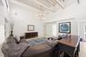 The heart of the home is an impressive open-concept living space defined by soaring vaulted ceilings, exposed beams, skylights, and an abundance of na