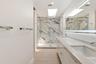 The spa-inspired primary bath showcases a sleek floating dual-sink vanity with quartz countertops, an illuminated designer mirror, and a stunning over