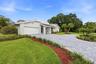 A striking first impression begins with a sweeping paver driveway, lush tropical landscaping, and timeless architectural details that set this home ap