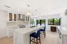 The heart of the home is an impressive open-concept living space defined by soaring vaulted ceilings, exposed beams, skylights, and an abundance of na