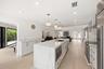 The beautifully renovated chef's kitchen showcases timeless white cabinetry, warm brushed gold accents, Carrara quartz countertops, and premium applia