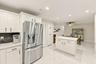 The impeccably upgraded kitchen offers white cabinetry, quartz countertops, stainless steel appliances, and a beautiful charcoal backsplash. There is 