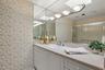 The primary bathroom offers abundant storage in a large vanity area and a full linen closet.
