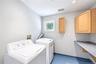 Seconf floor laundry with folding area and cabinetry