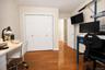 Wood-finish flooring throughout the room, featuring white bi-fold closet doors