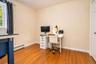 Hardwood flooring, painted walls, white trim, and a window with natural light used as an office