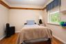 Hardwood flooring, painted walls, decorative shelving, and a window with trim