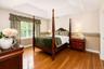 Hardwood flooring, tray ceiling, chair rail, and a bright window with blinds