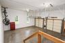 Two garage doors with openers,  concrete flooring, two windows, and overhead lighting