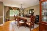 Hardwood flooring, chandelier with ceiling medallion, large window with decorative valance, built-in display cabinet