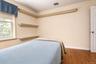 Hardwood flooring, , built-in shelving, paneled door, and a double-hung window
