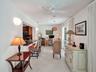 Open concept living area with light-toned flooring, an integrated breakfast bar, and a ceiling fan