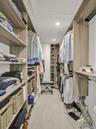 Custom closet organization system with wood-finish shelving and integrated hanging rods