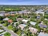 Aerial perspective showcasing a residential property with an outdoor swimming pool, surrounded by mature landscaping
