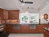 Custom wood-finish cabinetry with stainless steel appliances. 2 dish drawers and separate wet bar with seating.