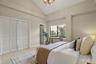 The primary suite with a large window overlooking the Park West garden and ornamental pond.
