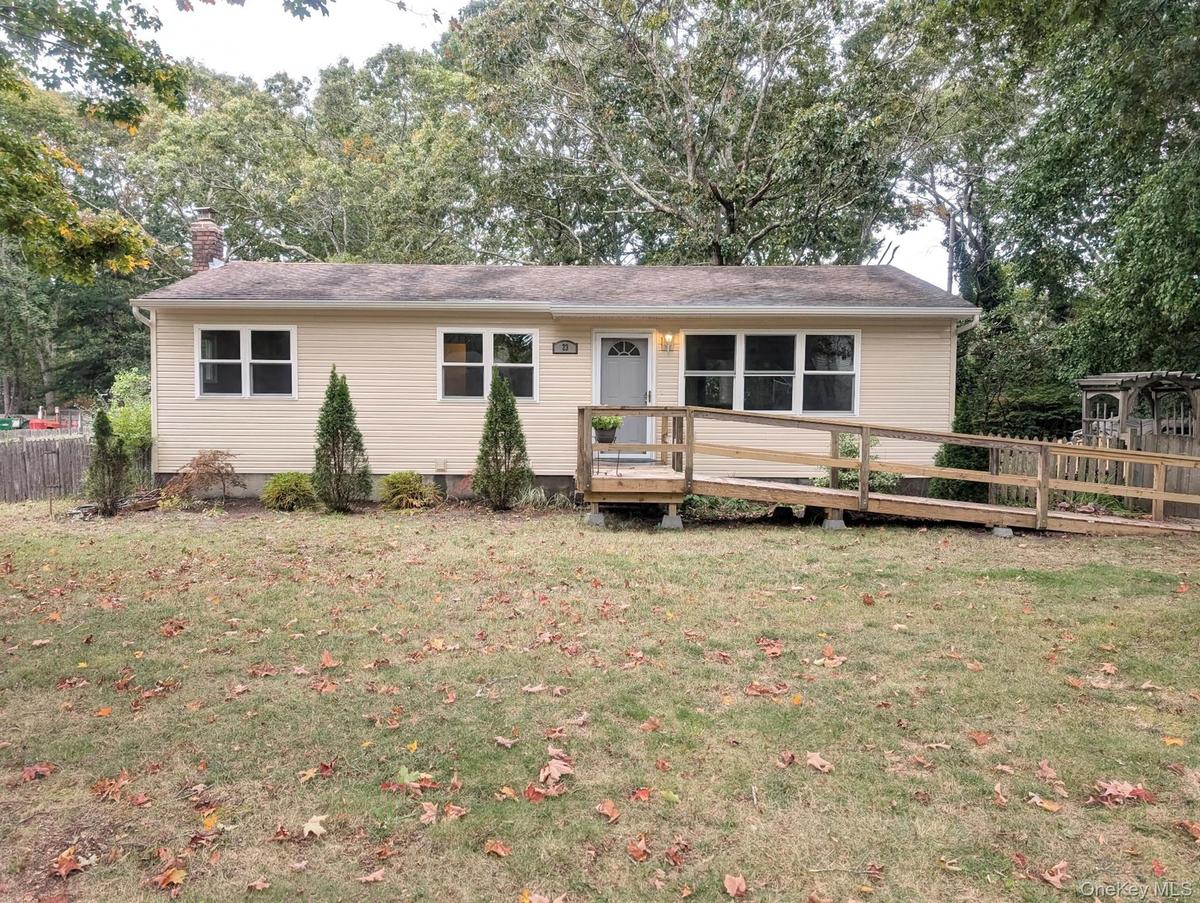 Light-colored siding, multiple windows, and a front entry ramp.