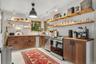 Modern country kitchen with stainless appliances, open shelving, herringbone wood counters