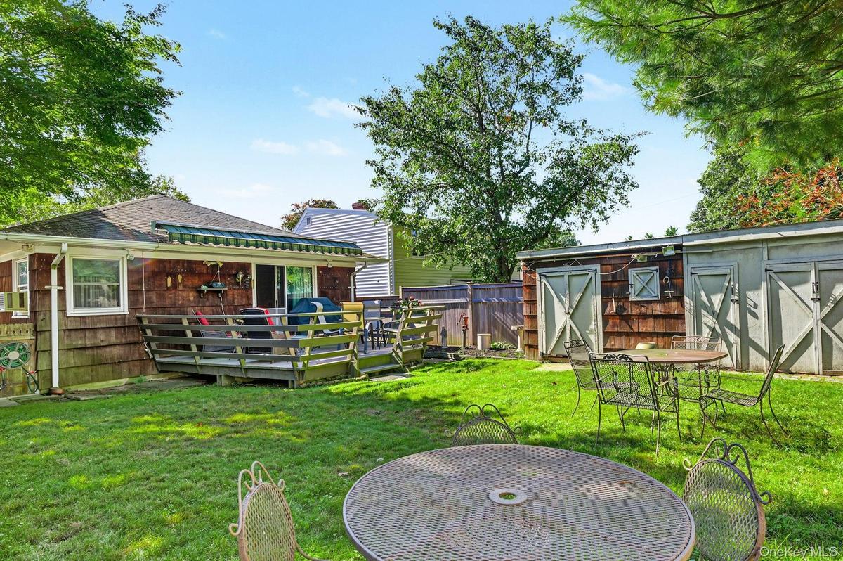 Private backyard with deck and garden beds—perfect for relaxing or entertaining.