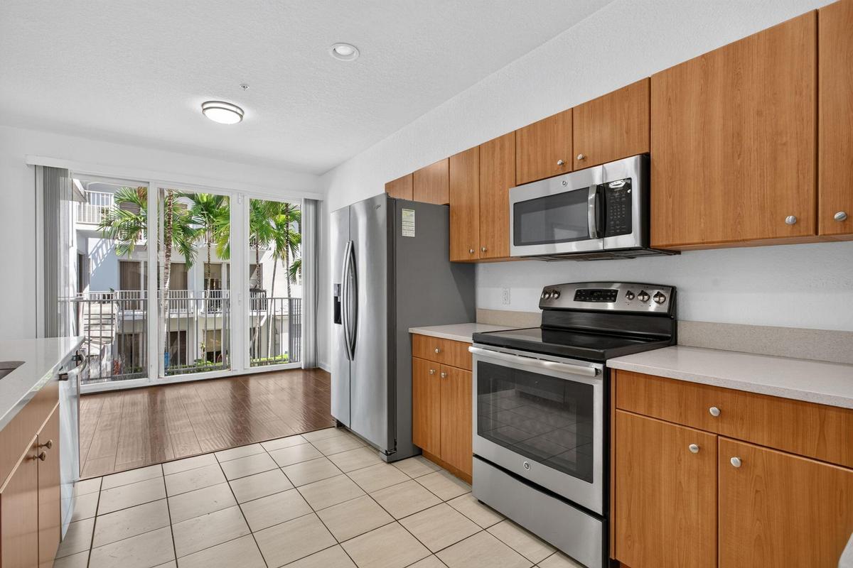 Kitchen featuring wood-finish cabinetry, stainless steel appliances, and light-toned countertops