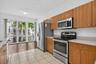 Kitchen featuring wood-finish cabinetry, stainless steel appliances, and light-toned countertops