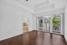 Tray ceiling, wood-finish flooring, sliding glass door, private balcony with black railings, and a built-in tub