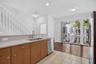 Kitchen featuring a double basin sink, light-toned countertops, and wood-finish cabinetry