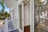 Sliding glass door access to a private balcony with white railing