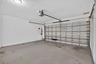 Garage with automatic overhead door opener and concrete flooring