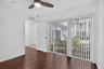 Wood-finish flooring, ceiling fan with integrated lighting, and full-height vertical blinds