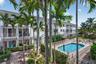 Two-story residences with balconies, a swimming pool with paved decking, and lush landscaping