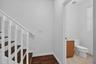 Wood-finish stairs with white risers and railing