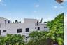 Contemporary multi-level exterior with flat rooflines, dark-framed windows, and multiple balconies with metal railings